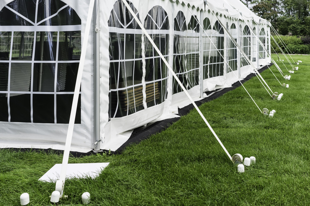 a garden wedding setup featuring a large marquee